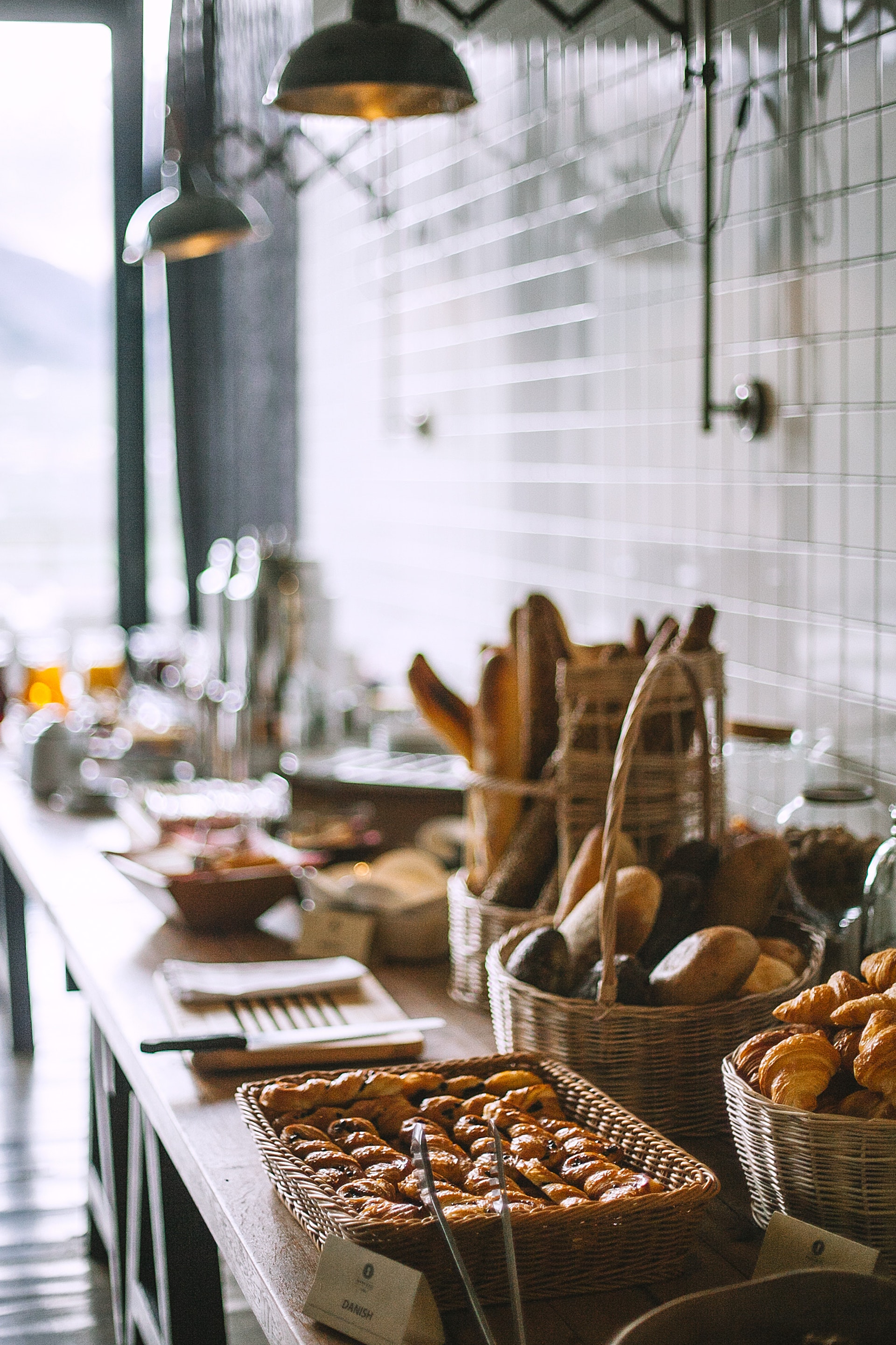 table traiteur pleine de pain et de viennoiserie pour le petit-déjeuenr
