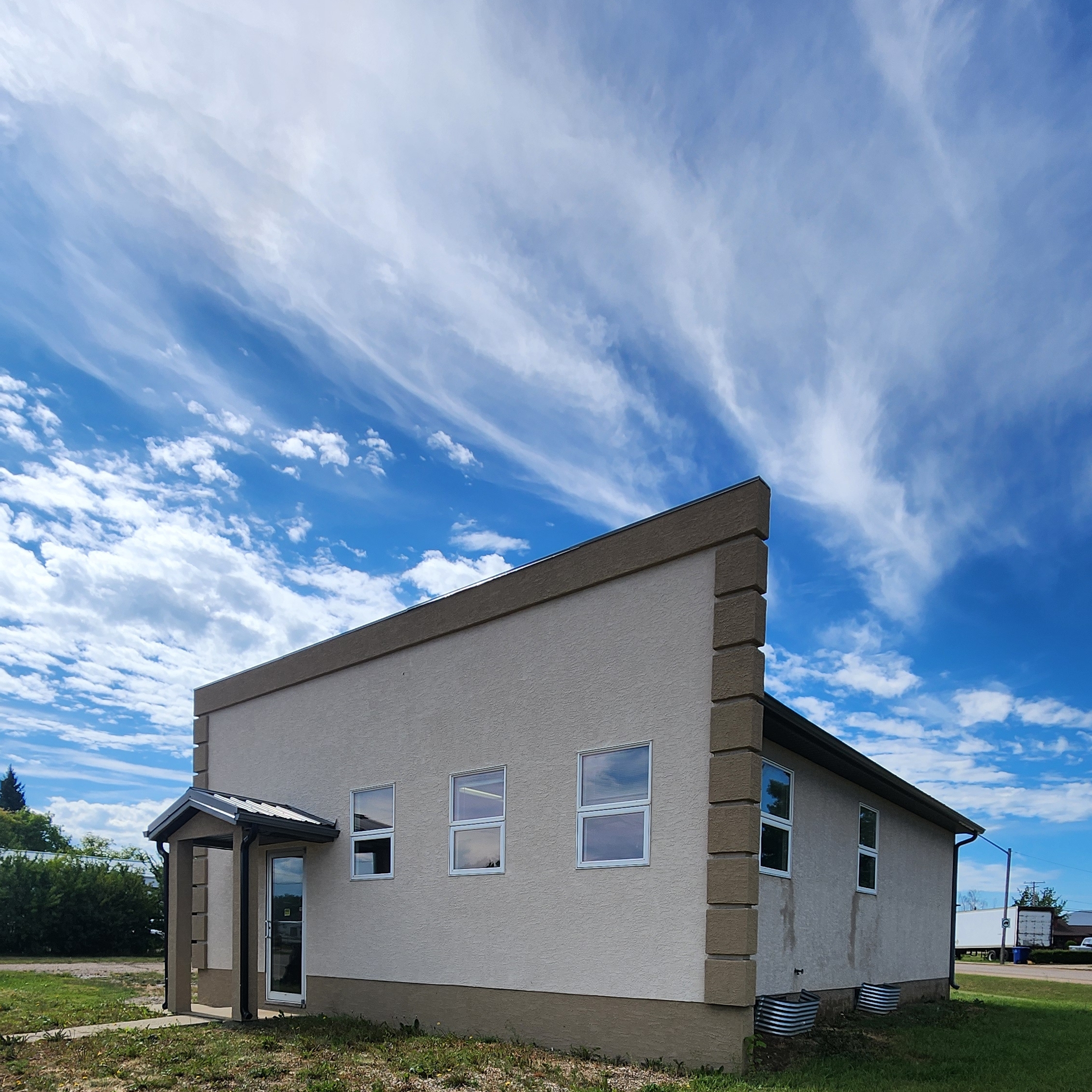 Exterior picture of brown stucco office building and blue sky